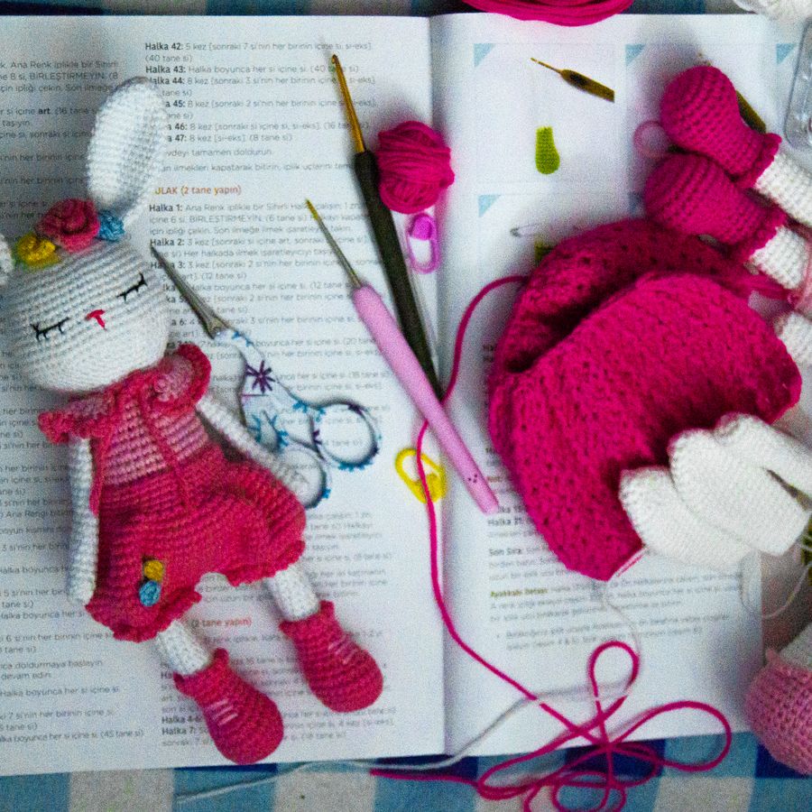 An open pattern booklet with the crocheted bunny it makes